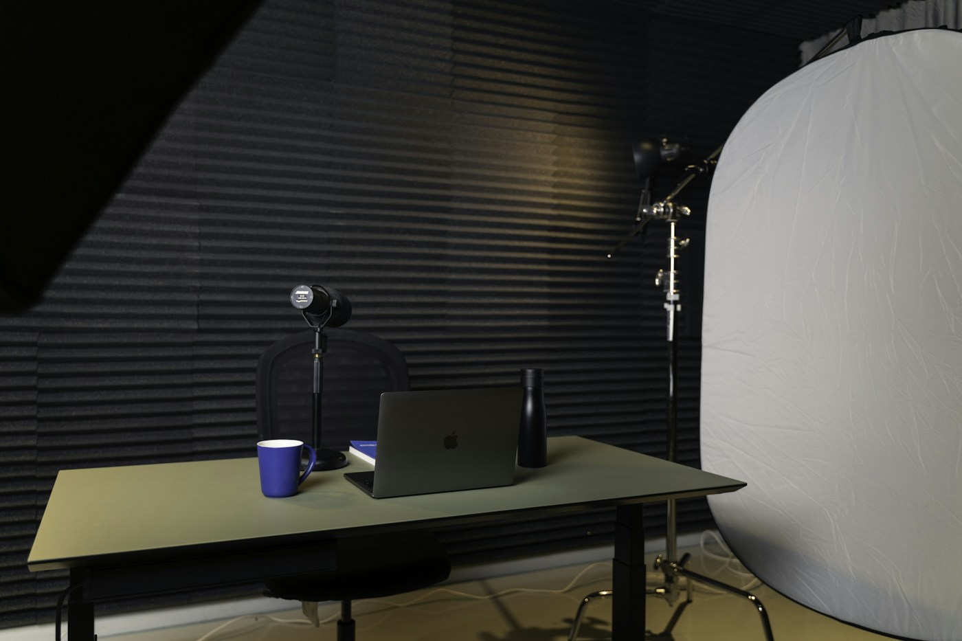 Laptop and microphone at a recording desk